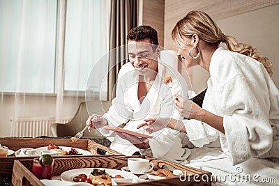 Wife and husband laughing watching funny movie and eating Stock Photo