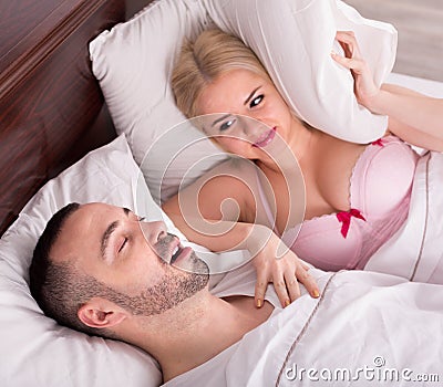 Wife with husband snoring in sleep Stock Photo