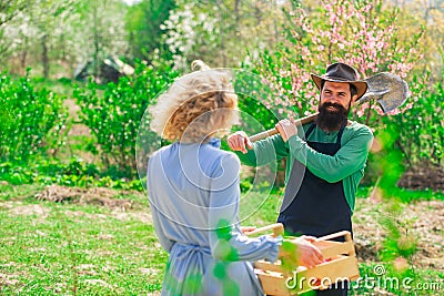 Wife and husband spend time in the orchard. Portrait of a young happy couple in yard during spring season. Homegrown Stock Photo
