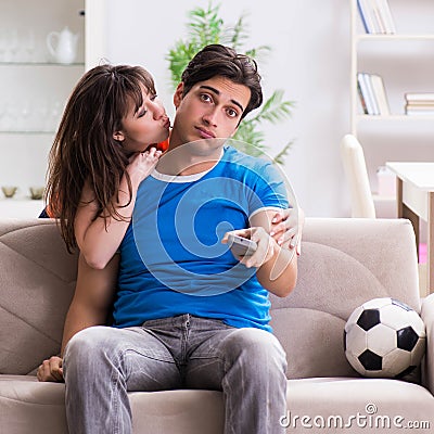 Wife unhappy that husband is watching football Stock Photo