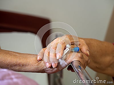 Wife visiting husband in hospital. Senior couple holding hands on hospital bed for hospitalization for supporting his dear. Concep Stock Photo