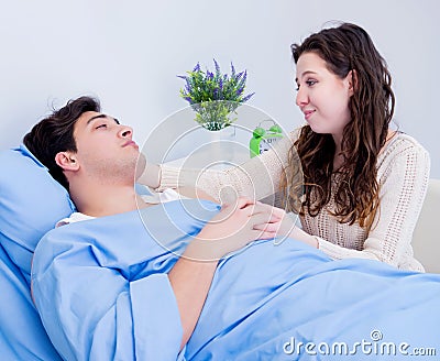 Wife visiting ill husband in the hospital room Stock Photo