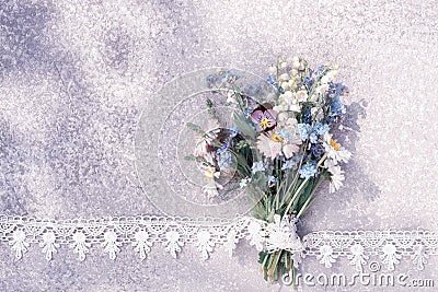 Wild flowers bouquet laying on an old rustic silver table in the lace frame Stock Photo