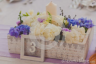 Wild flowers in a wooden tub on festive table Stock Photo