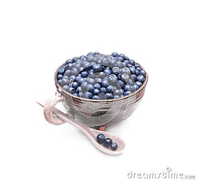 Wild forest blueberries in the clay pot with spoon isolated on white background Stock Photo