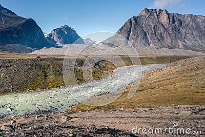 Wild Owl River winds through remote arctic landscape in Akshayuk Pass, Baffin Island, Canada. Moss valley floor and Stock Photo