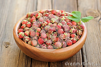 Wild strawberries Fragaria viridis with green leaf in wooden bow Stock Photo