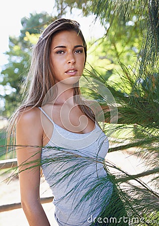 Wild, untamed beauty. A beautiful young woman standing outdoors in summer. Stock Photo