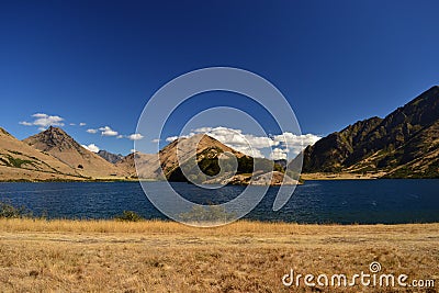 Wild west landscape, blue lake, dry mountains, savannas, desert land Stock Photo