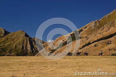 Wild west landscape, riders on horses, dry mountains, savannas, desert land Stock Photo