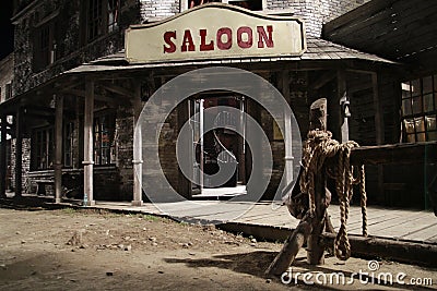 Wild west saloon front with hitch rack at night Stock Photo