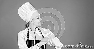 She will show you her high class cooking. Sensual cook pointing and looking away. Pretty chef inviting to her cooking Stock Photo