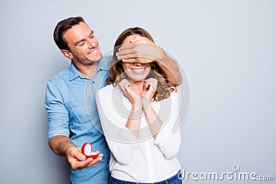 Will you marry me? Handsome man with bristle in jeans shirt making unexpected surprise for his beautiful, charming, joyful lover Stock Photo