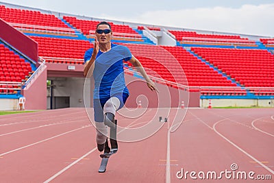 Willful Asian male athlete with prosthetics takes off speedily to surpass his running record on stadium track, motion blur depicts Stock Photo