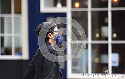 A woman wearing a face mask in public on the weekend that wearing face coverings became law in England Editorial Stock Photo