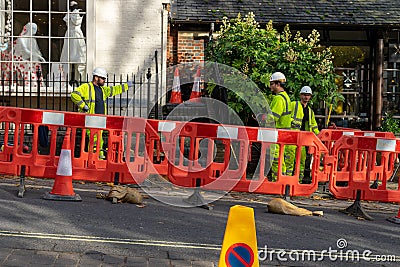 11/06/2019 Winchester, Hampshire, UK Three Builders in high visibility clothing behind a barrier in the road standing around Editorial Stock Photo
