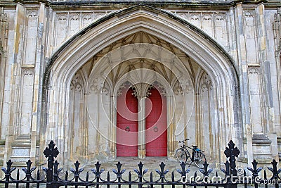 WINCHESTER, UK - FEBRUARY 5, 2017: Detail of the main entrance to the Cathedral with red doors and arches Editorial Stock Photo