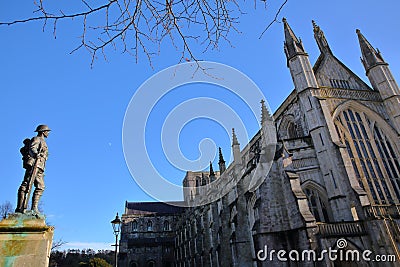 WINCHESTER, UK - FEBRUARY 4, 2017: Exterior view of the Cathedral with the statue of First World War Soldier on the left hand side Editorial Stock Photo