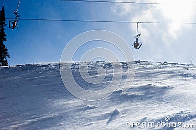 Wind blowing snow near lonely ski lift Stock Photo