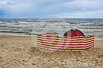 A wind-breaker and tent on the sand at the beach Stock Photo
