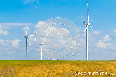 Wind energy turbines are one of the cleanest, renewable electric energy source, under blue sky with white clouds Stock Photo