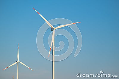 Wind generator on blue sky background.Natural energy.Windmill on sky background. renewable energy.Environmentally Stock Photo
