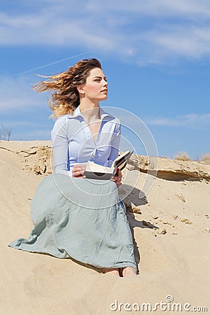 Wind hair woman reading a book on the beach Stock Photo