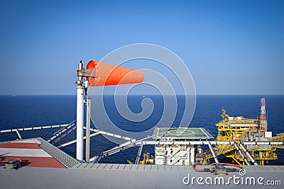 The wind sock is set on the oil rig to showing wind direction for helicopter ... Stock Photo