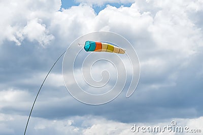 Wind sock. Wind designator against the blue cloudy sky. Wind sleeve flying close up Stock Photo