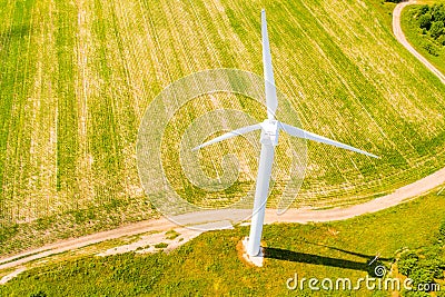 Wind turbine near path in farmland, aerial landscape. Renewable energy concept Stock Photo