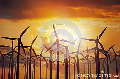 Wind turbines farm at sunset. Industry and energy generation concept Stock Photo