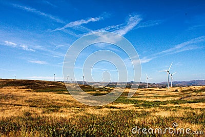 Wind turbines on hilly expanse create energy Stock Photo