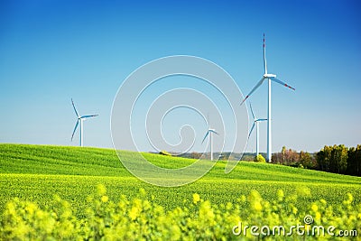 Wind turbines on spring field. Natural energy Stock Photo