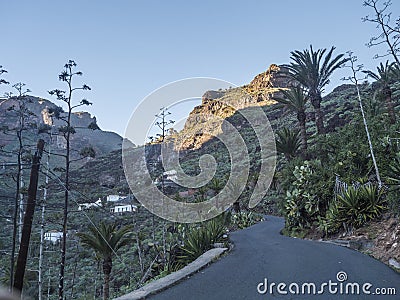 Winding road at Guarimiar village. At hiking trail through Barranco de Guarimiar Gorge. Green mountain canyon slopes Stock Photo