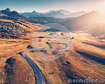 Winding road in mountain valley at sunset in autumn. Aerial view Stock Photo