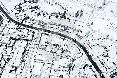 Winding road surrounded by residential houses covered by snow. aerial drone view Editorial Stock Photo
