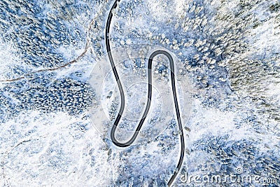 Road in the winter forest aerial view. Winding road without cars in the mountains. Stock Photo