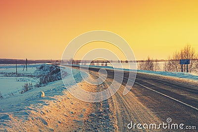 Winding winter road at sunrise Stock Photo