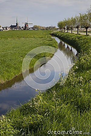 Windmill and church tower of the village Hoogmade at the horizon Editorial Stock Photo