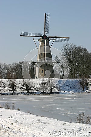 Windmill at frozen lake Stock Photo