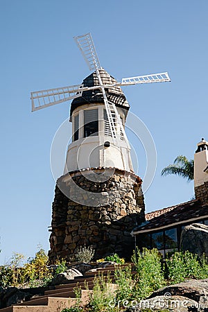 Windmill with old rock castle. red tile roof and string lights. Modern windmill. Country side on a bright summer day Stock Photo
