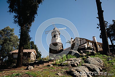 Windmill with old rock castle. red tile roof and string lights. Modern windmill. Country side on a bright summer day Stock Photo