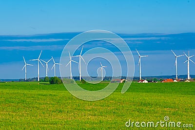 Windmill set.Wind generator and home in green field.Windmills on blue sky background.renewable energy. Environmentally Stock Photo