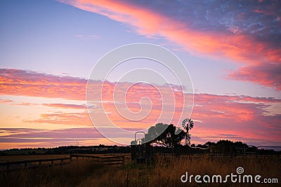 Windmill sunset at an Australian farm. The red sky Stock Photo