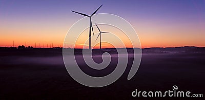 Windmill at Sunset . Wind turbines farm . Stock Photo