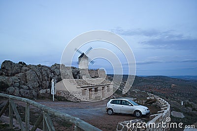 Windmill and white and dirty car near from a house in Los Yebenes, a small town in Toledo, Castile La Mancha, Spain Stock Photo