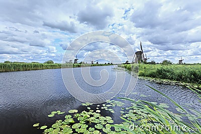 Windmills on a canal with dramatic shaped clouds Stock Photo