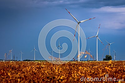 Windmills in the fields with dramatic rain clouds in the background Stock Photo