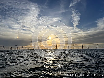 Windmills at sunset at Markermeer Stock Photo
