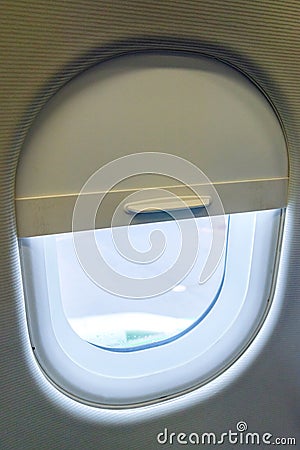 The window of the airplane. A view of porthole window on board an airbus for your travel concept or passenger air transportation Stock Photo